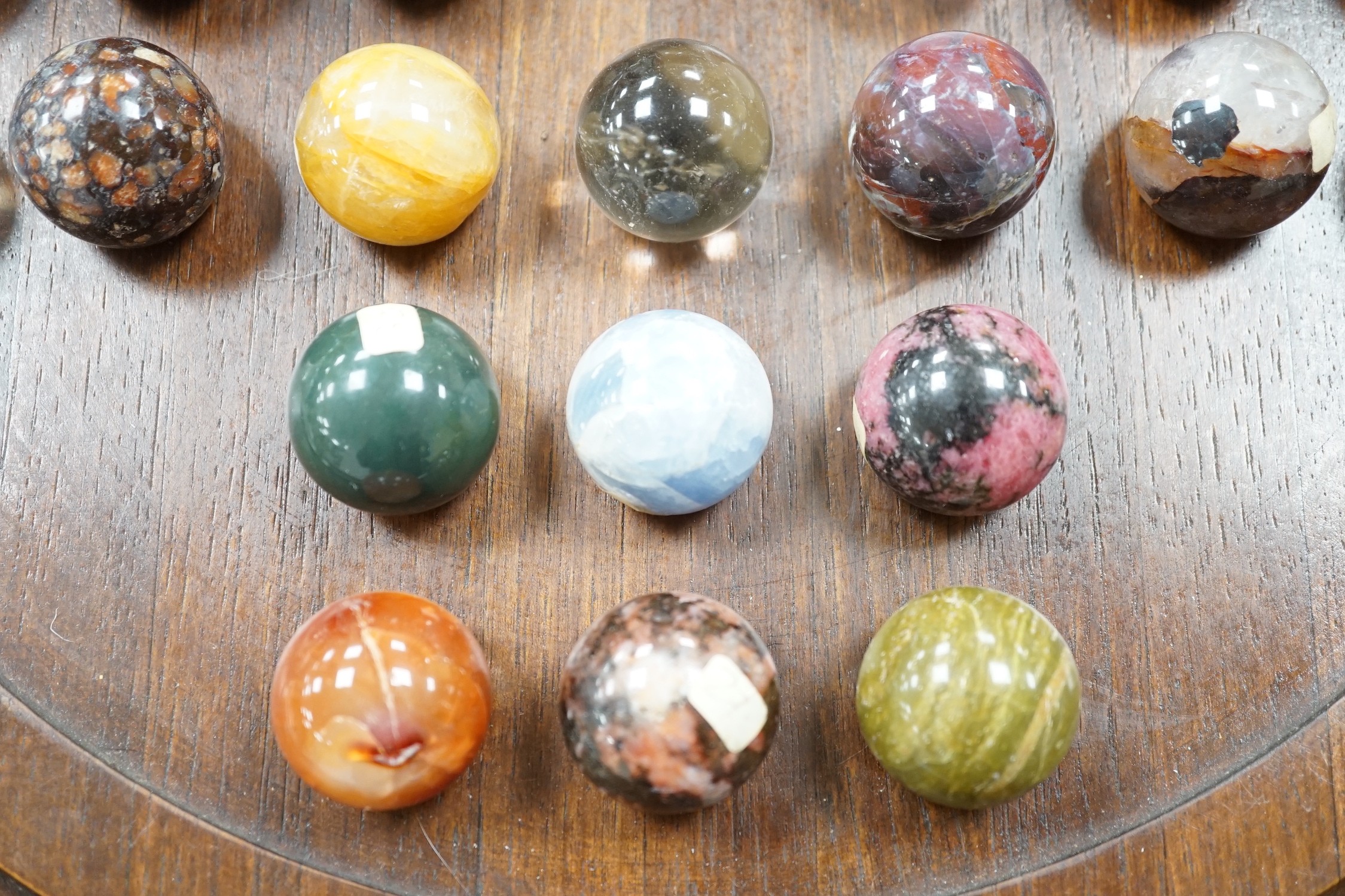 A large mahogany solitaire board with large specimen hardstone marbles, 42cm